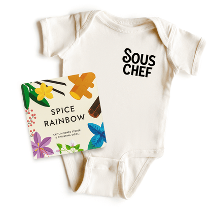 Chunky Deli product image: "Spice Rainbow" board book laid on top of a natural-colored "Sous Chef" onesie, showcasing both products together.