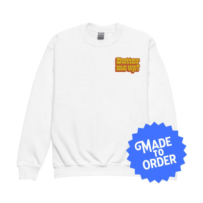 Chunky Deli product image: "Butter Me Up" pullover sweatshirt (soft fleece fabric, white color) laid flat on a white background, showcasing the long sleeves and the text "Butter Me Up" printed in orange and red across the chest.