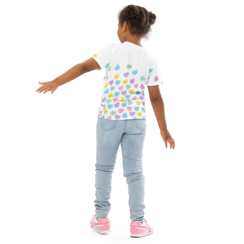 Chunky Deli product image: Close-up of a girl wearing the "Candy Hearts" t-shirt (white with colorful candy hearts featuring food illustrations) from the back, showing the design on the back of the shirt. She is wearing jeans and standing against a white 