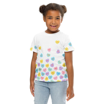 Chunky Deli product image: Close-up of a smiling girl wearing the "Candy Hearts" t-shirt (white with colorful candy hearts featuring food illustrations), wearing jeans, against a white background.