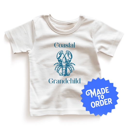 Chunky Deli product image: Natural-colored "Coastal Grandchild" with a lobster illustration kids and toddler t-short 100% cotton laid flat on a white background.