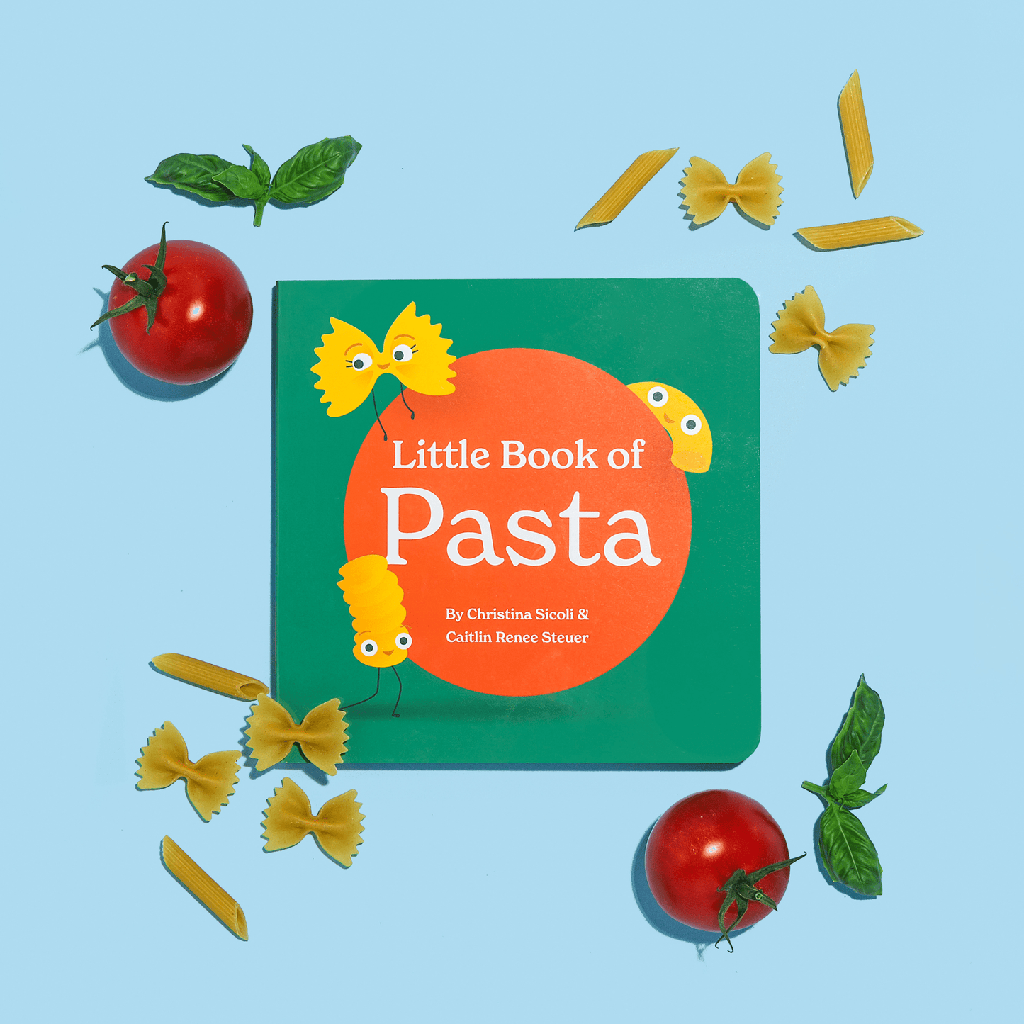 Chunky Deli product image: "Little Book of Pasta" cover displayed on a blue background with raw pasta, tomatoes, and basil, showcasing the book in a playful format contrasting flat illustrations with real food.