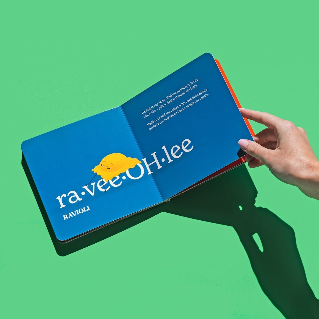 Chunky Deli product image: "Little Book of Pasta" open to the ravioli spread (blue page), featuring an illustration of a sleepy ravioli and its accompanying playful rhyme, held open by one hand against a green background.