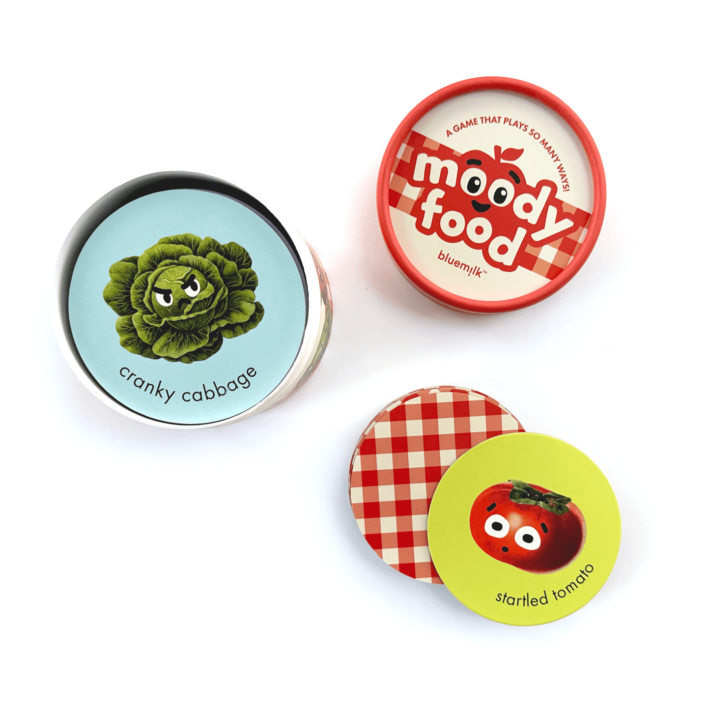 Chunky Deli product image: Top-down view of the "Moody Food" card game, showing the cylinder box cover and a few example cards (cabbage and tomato) laid on a white background.