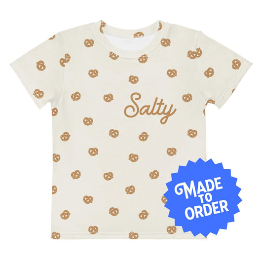 Chunky Deli product image: Kids' and toddler t-shirt with an all-over pretzel pattern and the word "Salty" written on the chest. The t-shirt has short sleeves, a crew neck collar, and a unisex cut.