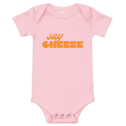 Chunky Deli product image: Pink-colored "Say Cheese" icon onesie, 100% cotton with envelope shoulders and three-snap closure, laid flat on a white background.