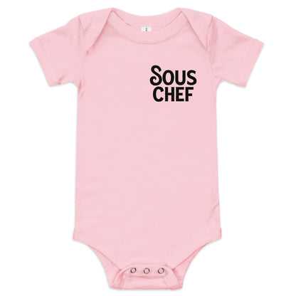 Chunky Deli product image: Pink-colored "Sous Chef" onesie (100% cotton) laid flat on a white background, showcasing the envelope shoulders and three-snap closure.